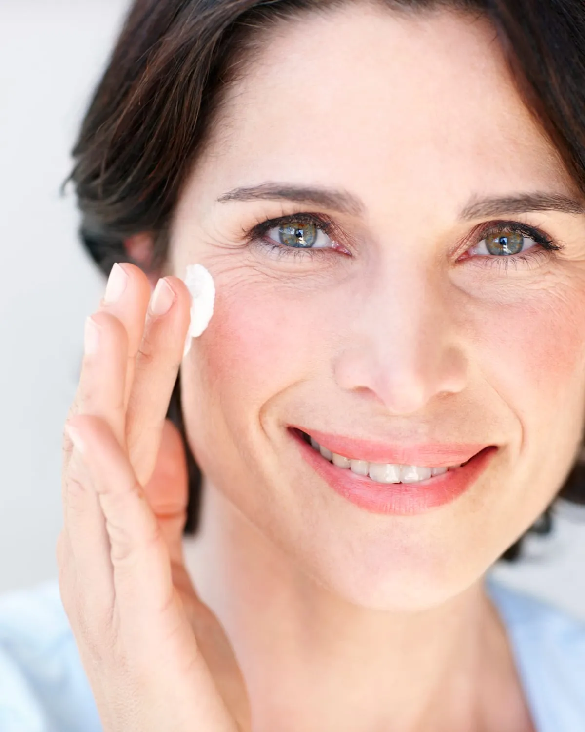 Woman applying facial cream