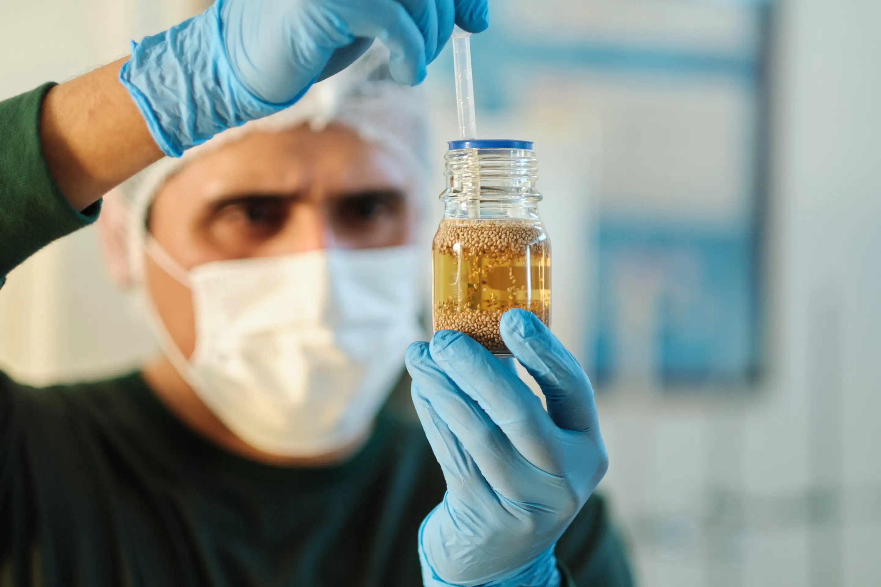 Benexia technician inspecting a jar of chia mucilage in the quality laboratory